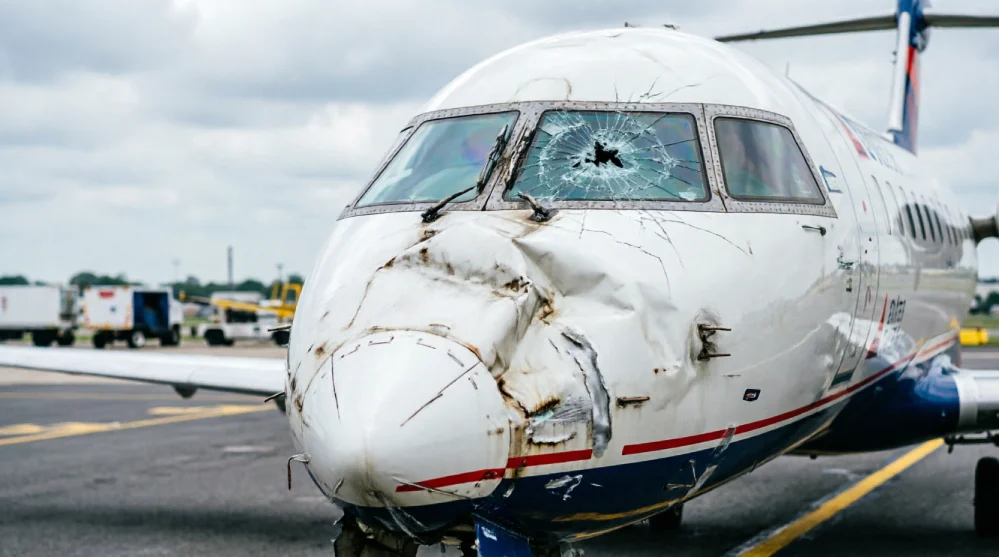 Damaged nose and shattered cockpit windows of a Delta Connection CRJ900 after a ground collision at LaGuardia Airport.
