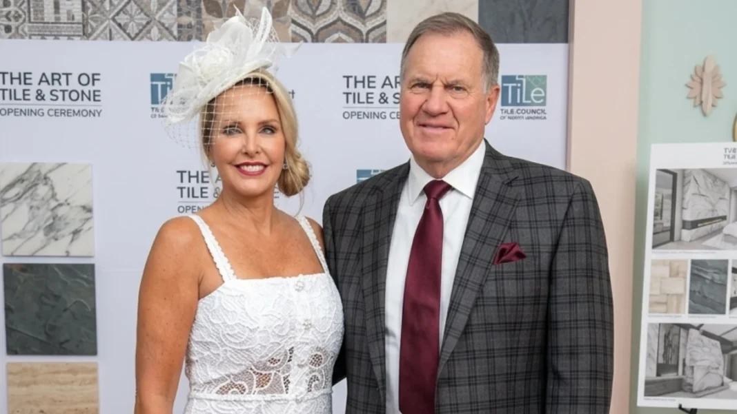 Debby Clarke Belichick in white dress at The Art of Tile & Stone opening ceremony event in Wellesley Massachusetts with business backdrop and tile samples display
